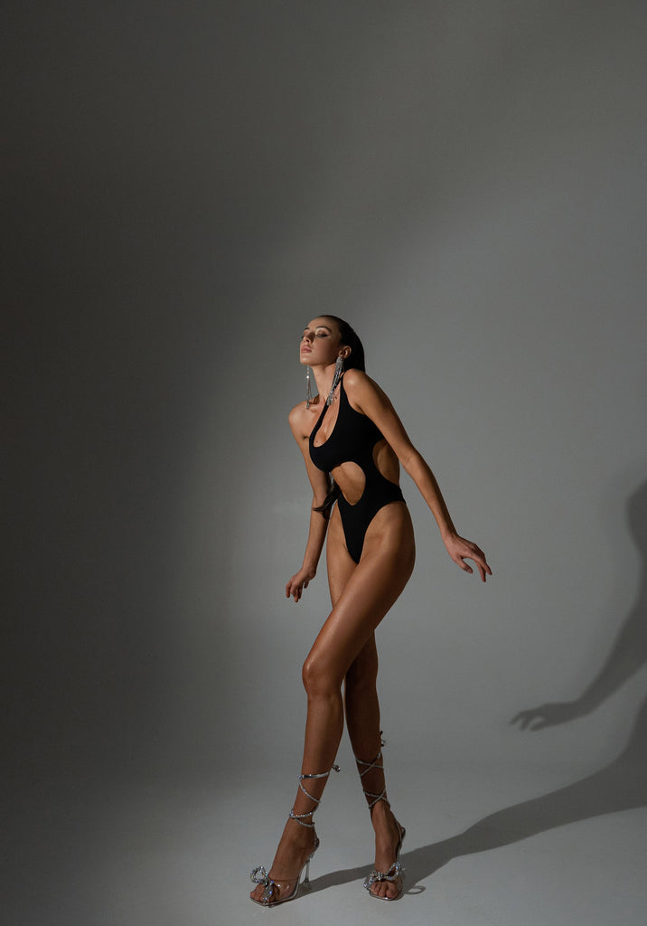 High-leg black silhouette sculpting the waist and enhancing proportions.