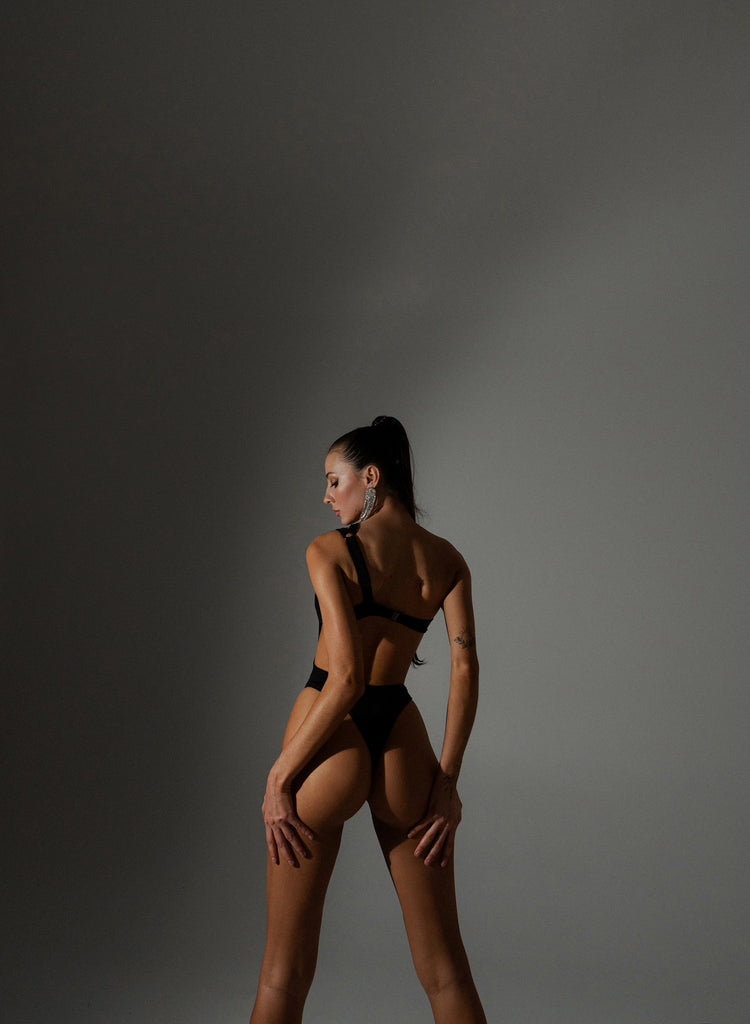 Glossy black swimwear built to retain color and structure over time.